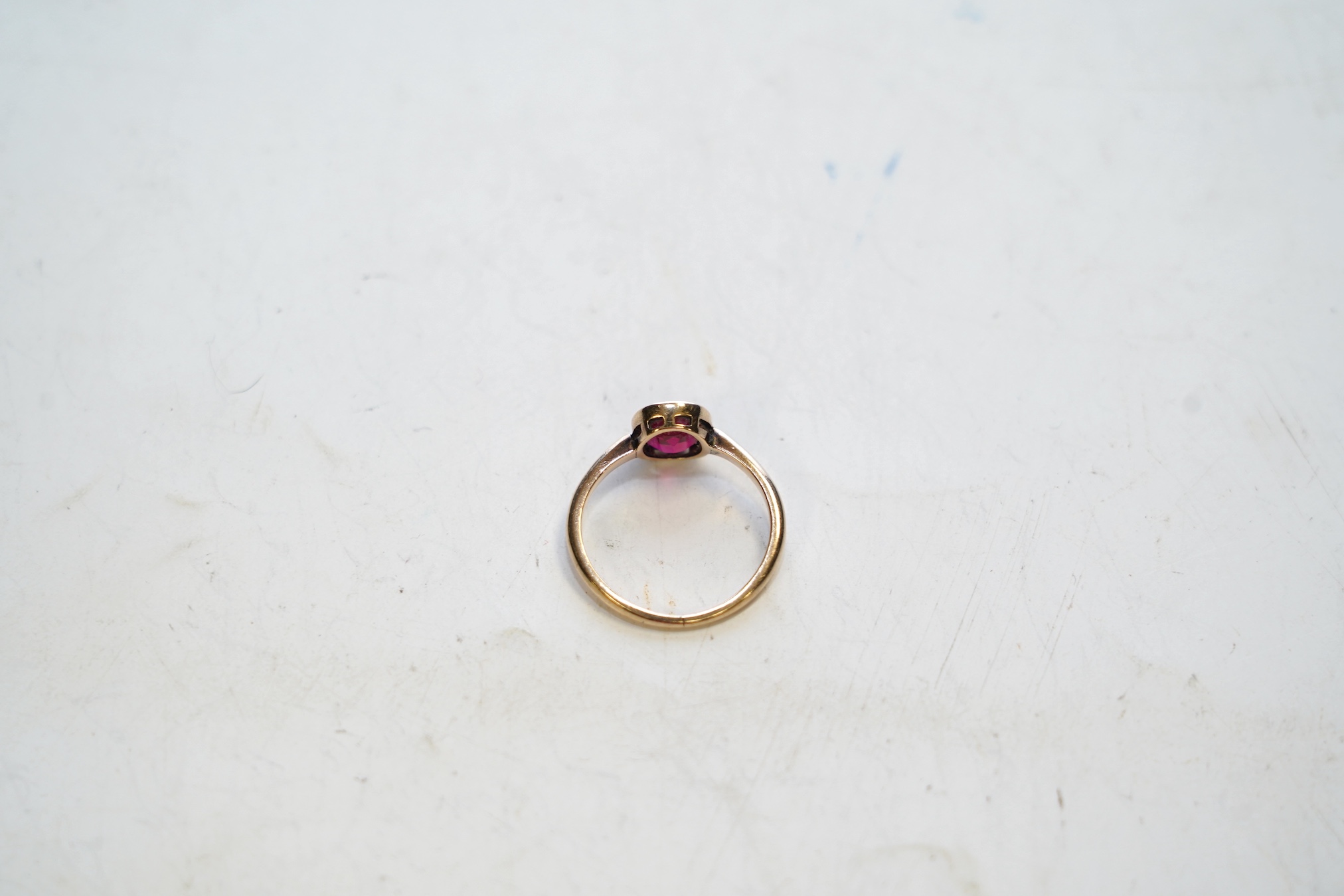 A yellow metal and single stone oval cut synthetic ruby set ring, size L, gross weight 2 grams. Condition - good